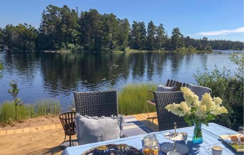 a table and chairs with a view of a lake at 4 Bedroom Lovely Home In Lammhult in Lammhult