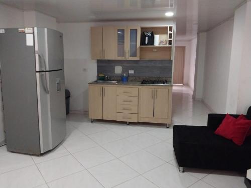 uma cozinha com um frigorífico e um sofá num quarto em HABITACIÓN PRIVADA tranquila y confortable em Bello