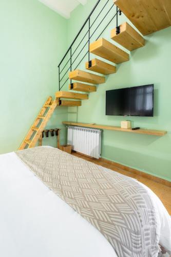 a bedroom with a bed and a tv on the wall at Breathe Hotel in Batroûn