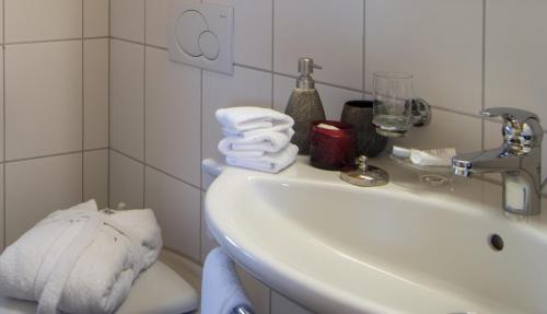 a bathroom with a sink and towels on a toilet at Alpenhof in Davos