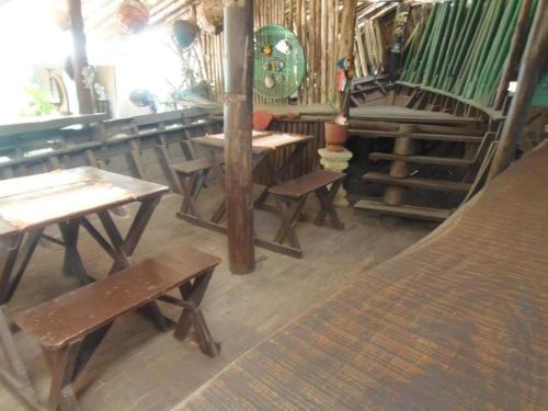 a group of tables and benches in a room at Pousada Bora Bora in Guarapari