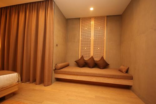 a bench in a room with a window at Chu Hotel in Chiang Mai