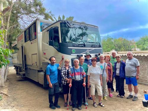 a group of people standing in front of a bus at HUANCHACO GARDENS in Huanchaco