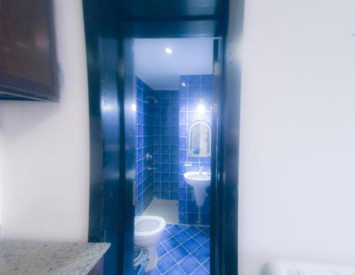 bagno blu con servizi igienici e lavandino di Family Apartment in Porto Sharm a Sharm El Sheikh