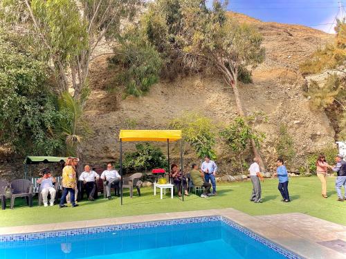 a group of people standing around a pool at HUANCHACO GARDENS in Huanchaco