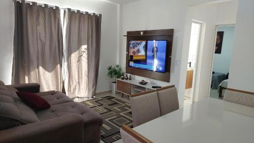 un soggiorno con divano e TV a schermo piatto di Apartamento belvedere do lago a Serra Negra