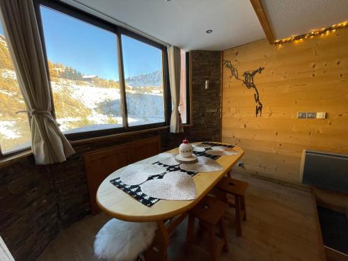 une salle à manger avec une table et une fenêtre dans l'établissement Isola 2000 centre galerie 6 couchage 35m2 aux pieds des pistes, à Isola 2000