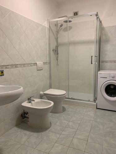 bagno con lavandino e servizi igienici e lavatrice. di Casa del Lago a Pignola