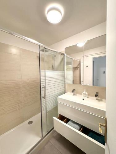 une salle de bain blanche avec un lavabo et une douche dans l'établissement Appartement T3,T4, à Aubagne