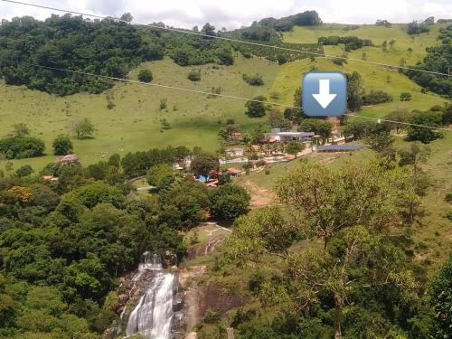 eine Luftansicht eines Wasserfalls auf einem Hügel mit einem Apfellogo in der Unterkunft Pousada Vale do Café in Bueno Brandão