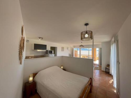 Cet appartement comprend une chambre avec un lit blanc et une cuisine. dans l'établissement Maisonnette calme vue collines, à Marseille