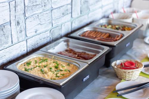 a buffet with three trays of food on a table at Penzion Praděd Thamm in Zlaté Hory