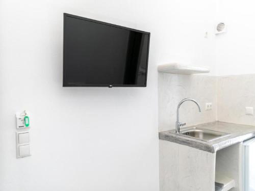 a flat screen tv hanging on a wall with a sink at Depis Place And Apartments Naxos Depis Castle Renata Luxury Apartments-Double Studio in Naxos Chora