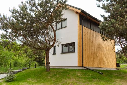 a house with black windows and a tree at Ossona Rest in Częstochowa