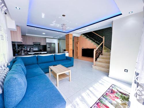 Il comprend un salon avec un canapé bleu et une cuisine. dans l'établissement Luxury duplex with private pool - Sea view and Fast wifi, à Oued Laou
