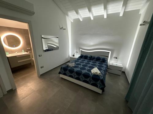 a bedroom with a blue bed in a white room at Le Potager in Quartu SantʼElena