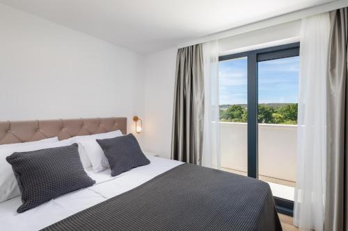 a bedroom with a bed and a large window at Villa Mint in Rogoznica