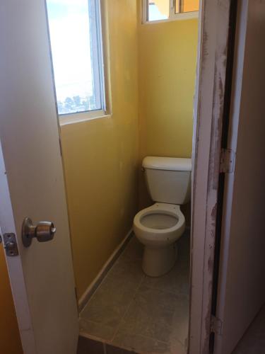 a bathroom with a toilet and a window at Hospedaje Barato Mi Casita de Colores in Tijuana