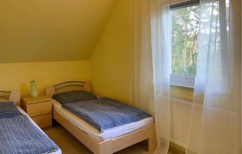 1 Schlafzimmer mit 2 Betten und einem Fenster in der Unterkunft Ferienhaus Seeblick H in Herzsprung
