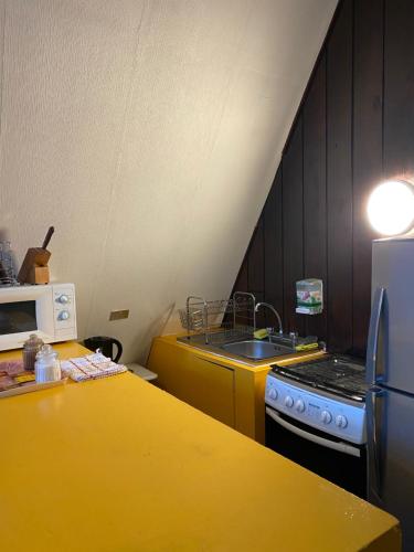 a kitchen with a yellow counter top and a stove at Centro Turístico Anticura Parque Nacional Puyehue in Anticura