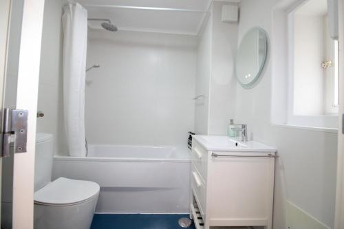 Baño blanco con aseo y lavamanos en Casa S. Miguel 6, en Oporto