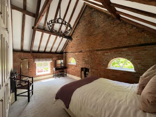 a bedroom with a bed and a brick wall at The Old Barn in Market Rasen