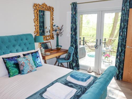 a bedroom with a large bed with a blue couch at Kingfisher Chalet in Chester