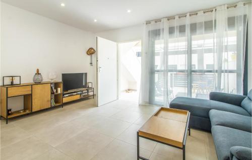 ein Wohnzimmer mit einem blauen Sofa und einem Fernseher in der Unterkunft Nice Home In San Pedro Del Pinatar in San Pedro del Pinatar