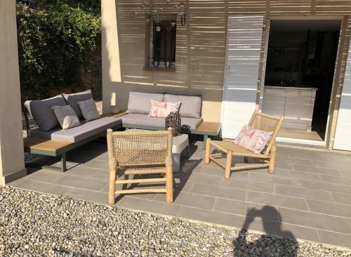 une terrasse avec des chaises et des canapés dans une maison dans l'établissement Villa de Charme magnifique vue Panoramique et Piscine, à Lorgues