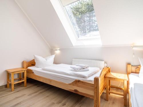 um quarto com uma cama e uma clarabóia em Ferienhaussiedlung Strandperlen Weidenhof 6b (Typ IX) em Wustrow