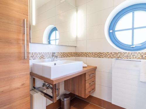 a bathroom with a sink and a mirror at Ferienhaussiedlung Strandperlen Weidenhof 6b (Typ IX) in Wustrow