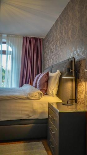 a bedroom with a bed with a lamp and a window at or'o apartments in Žabljak
