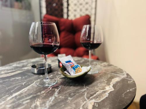 two glasses of red wine and a bowl of snacks on a table at Bizant Boutique Hotel & Coffee,Bar in Durrës