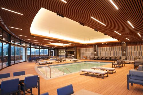 Muckleshoot Casino Resort في أوبورن: مسبح في مبنى فيه كراسي وطاولة