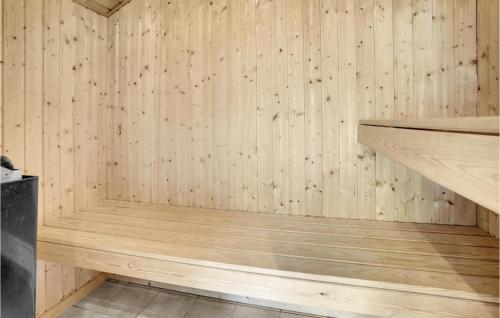 a sauna with wooden walls and a wooden bench at Holiday Home Strandparken Xi in Otterup