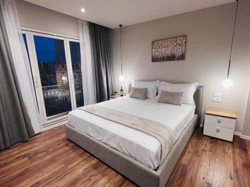 a bedroom with a large bed and a large window at Bizant Boutique Hotel & Coffee,Bar in Durrës