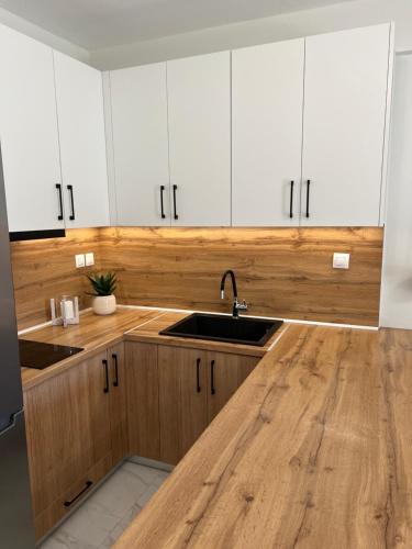 a kitchen with white cabinets and a sink at Ioannis Villa in Nea Fokea
