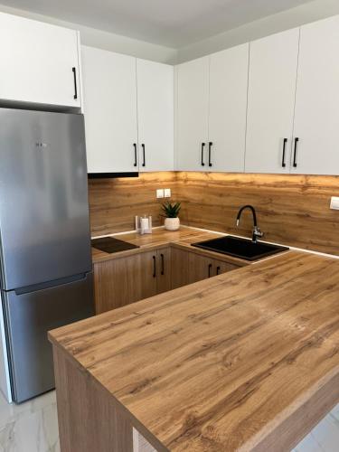 a kitchen with white cabinets and a wooden counter top at Ioannis Villa in Nea Fokea
