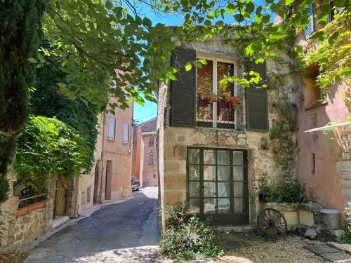 Une allée dans un ancien bâtiment avec une fenêtre dans l'établissement Vérité Maison de Lorgues village center- Charming 2 bed 2 bath oasis, à Lorgues