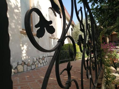 una recinzione di ferro con un fiore sopra di fronte a un edificio di Agriturismo Vemi a Santa Sofia dʼEpiro