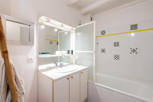 uma casa de banho branca com um lavatório e uma banheira em Atlantic Selection - Le Boudigau avec parking em Capbreton