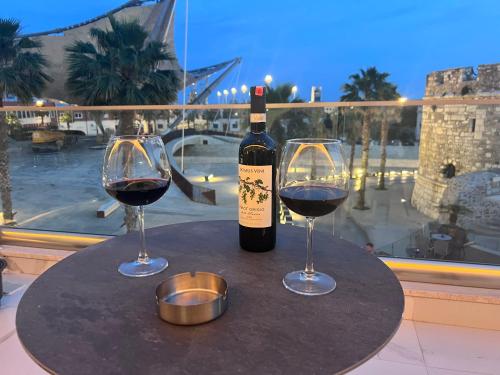 a bottle of wine and two glasses on a table at Bizant Boutique Hotel & Coffee,Bar in Durrës
