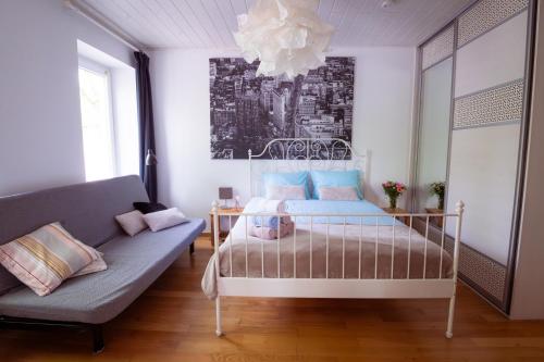 a bedroom with a bed and a couch at Riverview Residence - with parking in Ljubljana