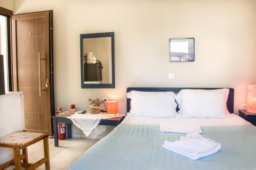 a bedroom with a bed and a table and a mirror at Christina Rooms in Adamas