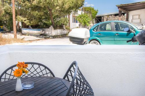 a table with a vase of flowers and a car at Christina Rooms in Adamas