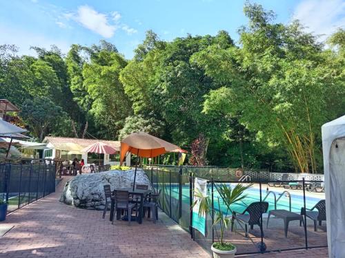 a patio with tables and chairs next to a pool at Eco Hotel Entre Ríos in Villeta