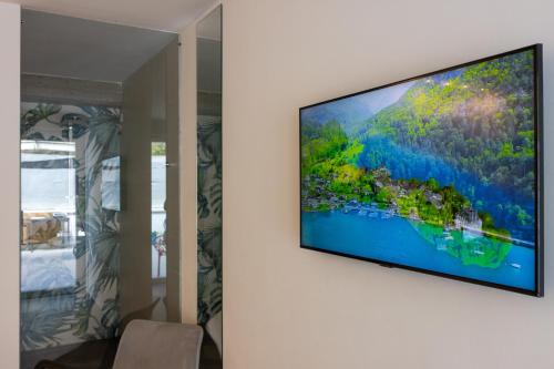 Elle comprend une télévision à écran plat suspendue au mur. dans l'établissement Tropicana Suite - Adults Only, à Agropoli