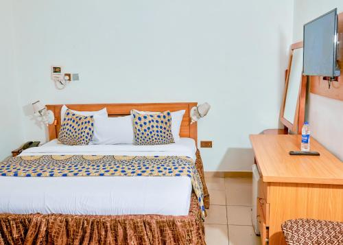 Cette chambre comprend un lit et un bureau. dans l'établissement Definite Destiny Hotel by YOTRAD, à Lagos