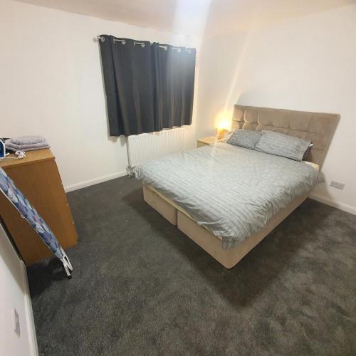 a small bedroom with a bed and a window at Beautiful place near Dagenham East Station in Dagenham