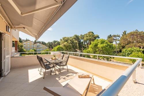 a patio with a table and chairs on a balcony at Apartments L&D in Biograd na Moru